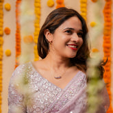 Woman in a silver saree with a decorative background